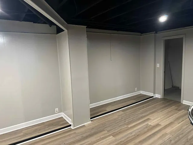 a view of empty room with wooden floor