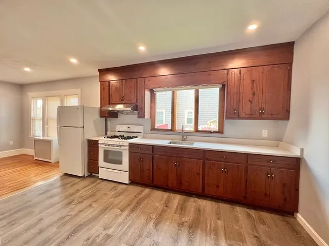 a large kitchen with stainless steel appliances granite countertop a sink and a stove