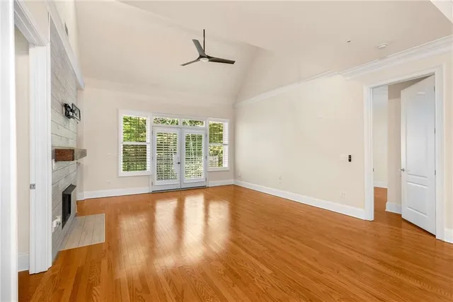 a view of empty room with wooden floor and fireplace