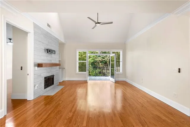 a view of empty room with wooden floor and fireplace