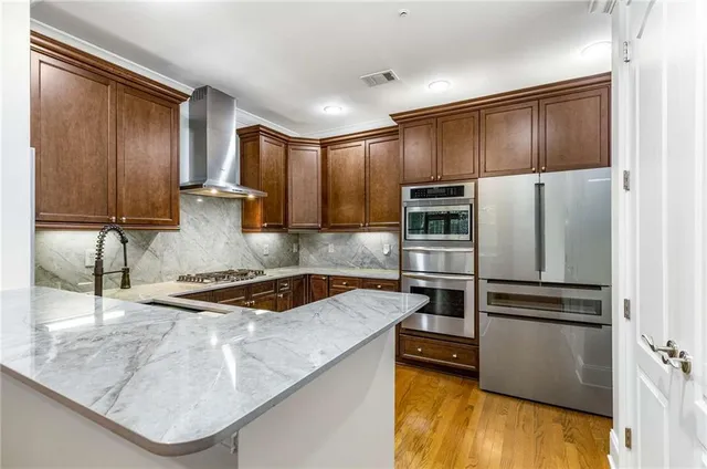 a kitchen with stainless steel appliances granite countertop a refrigerator and a stove