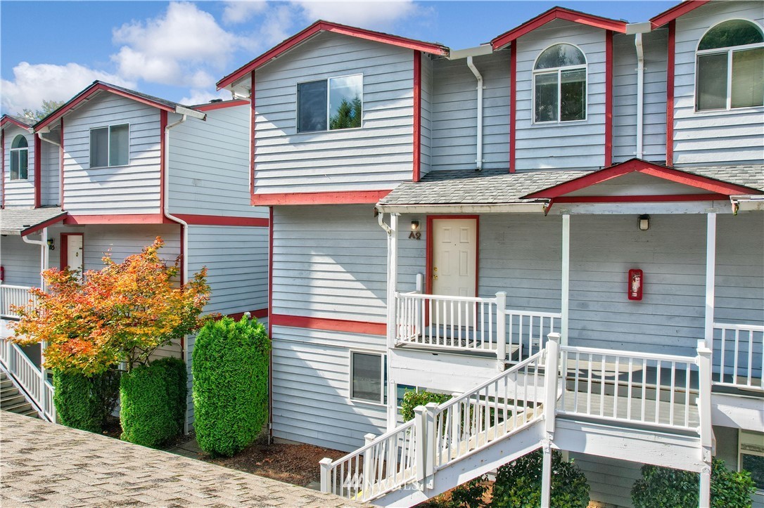 a view of a house with a yard and potted plants