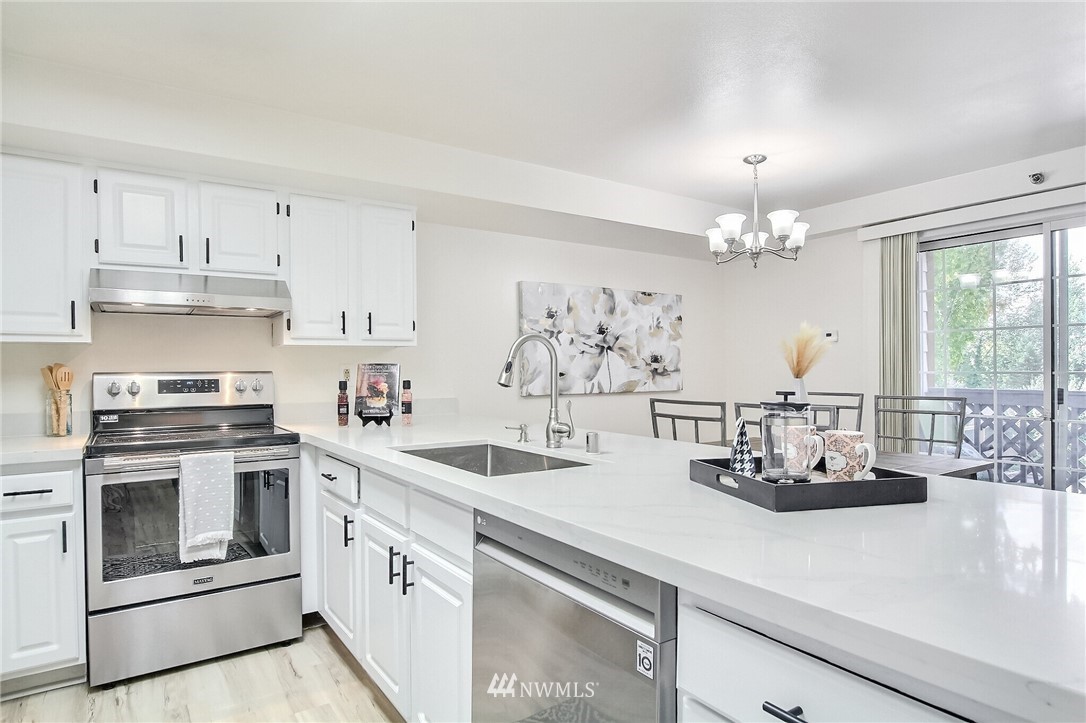 3939 10th Street Southeast, Unit A2 Puyallup, WA 98374 - Photo 13 of 27 a kitchen with kitchen island white cabinets and white appliances
