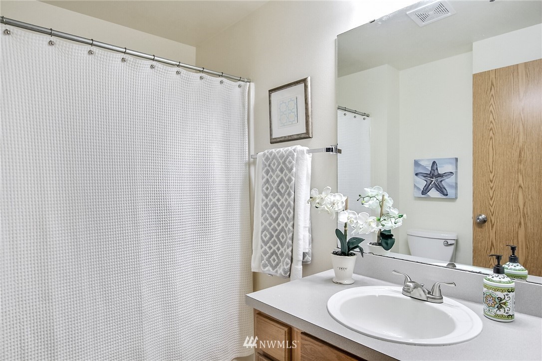 3939 10th Street Southeast, Unit A2 Puyallup, WA 98374 - Photo 16 of 27 a bathroom with a sink a mirror and a shower curtain