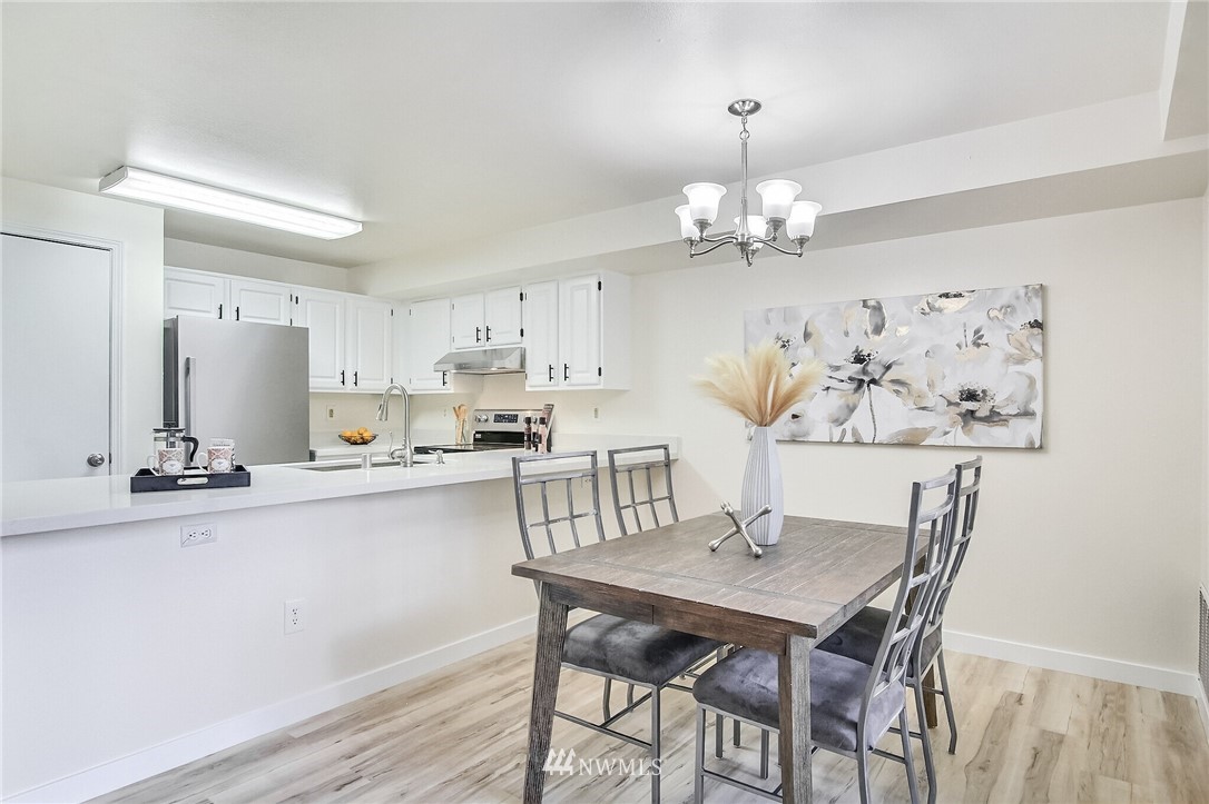 3939 10th Street Southeast, Unit A2 Puyallup, WA 98374 - Photo 10 of 27 a kitchen with stainless steel appliances granite countertop a dining table chairs and a refrigerator