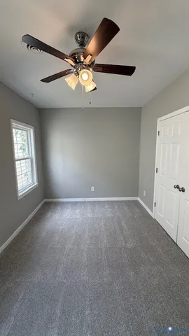a view of a livingroom with a ceiling fan and window