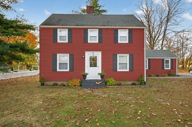 a front view of brick house with a yard