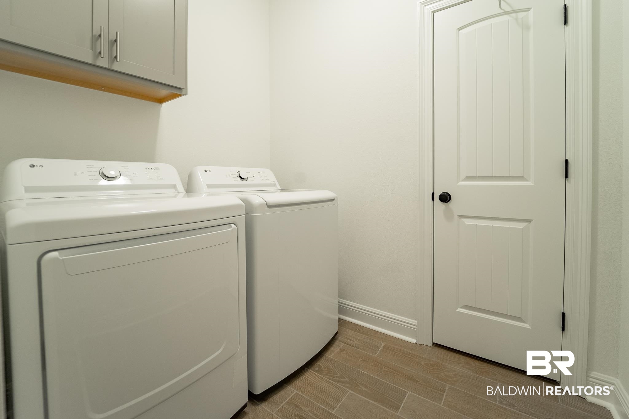 896 Sumter Loop Foley, AL 36535 - Photo 21 of 23 Washroom with cabinets, light wood-type flooring, and washer and clothes dryer