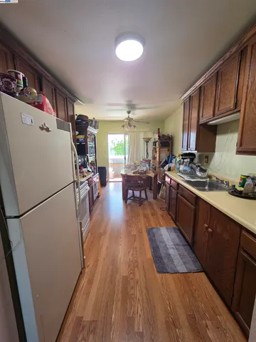 a kitchen with stainless steel appliances a refrigerator a stove a sink dishwasher and a refrigerator with wooden floor