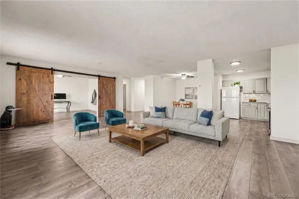 a living room with furniture and a wooden floor