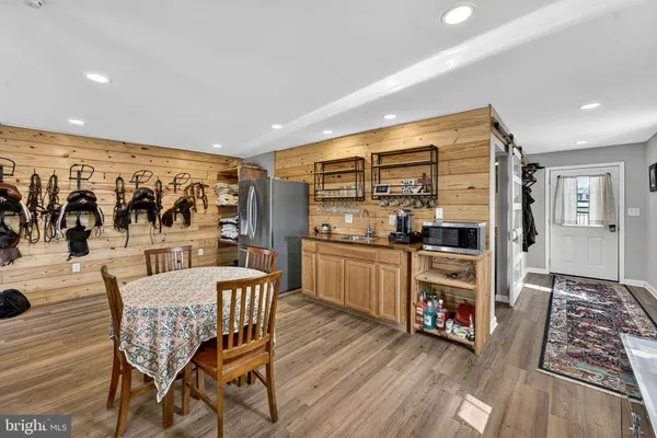 a kitchen with stainless steel appliances wooden floor and dining table