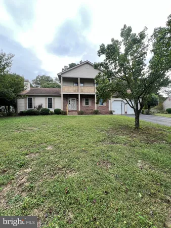 a view of a house with a big yard and large trees