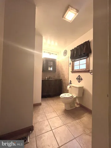 a bathroom with a toilet a sink and a mirror