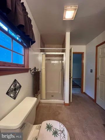 a bathroom with a toilet and a shower