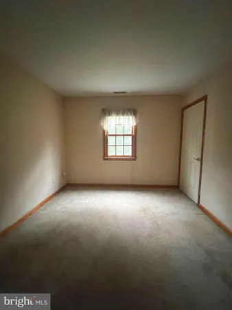 a view of an empty room with a fireplace and a window