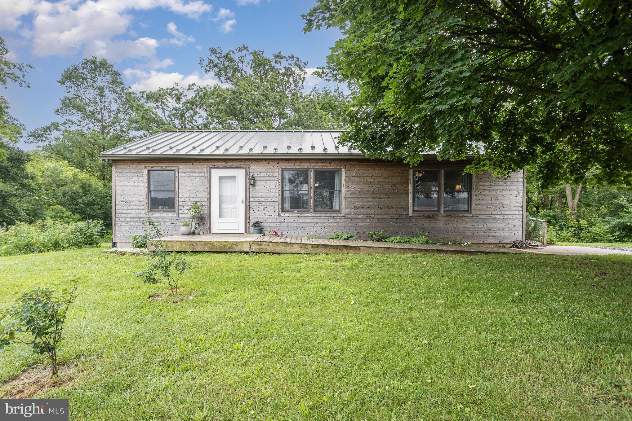 1281 Creek Road Manheim, PA 17545 - Photo 1 of 4 a backyard of a house with table and chairs plants and large tree