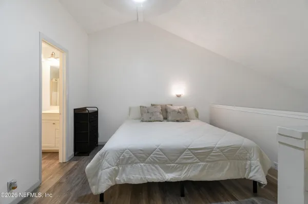 a bedroom with a bed and wooden floor