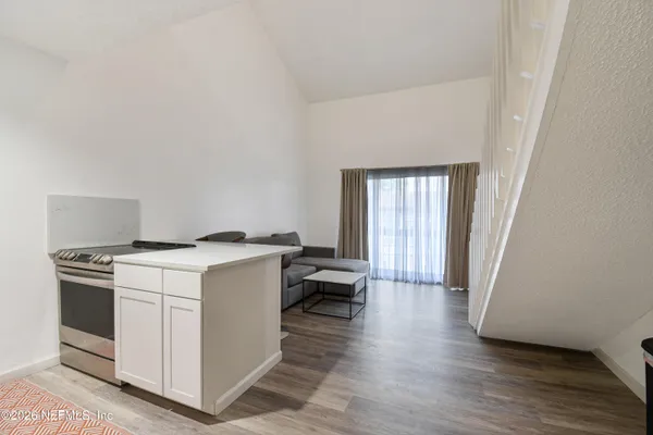 a view wooden floor and kitchen stove a sink and dishwasher with wooden floor