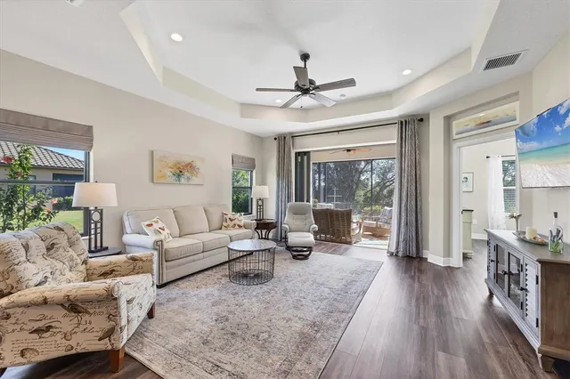 a living room with furniture large window and wooden floor