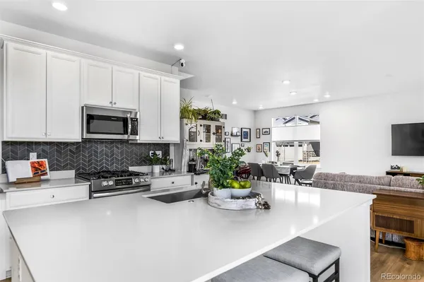 a living room with furniture a flat screen tv and kitchen view