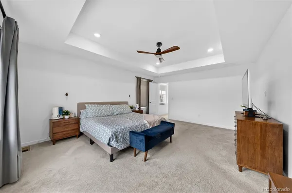 a spacious bedroom with a bed and a chandelier