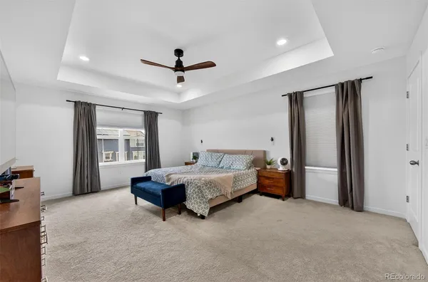 a spacious bedroom with a bed and a chandelier