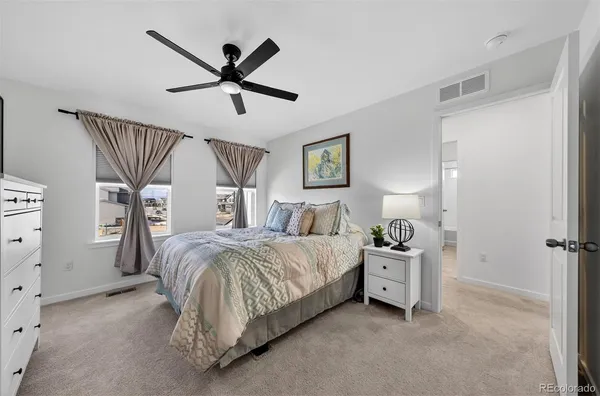 a bed room with a bed and a ceiling fan
