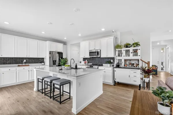 a kitchen with white cabinets and stainless steel appliances