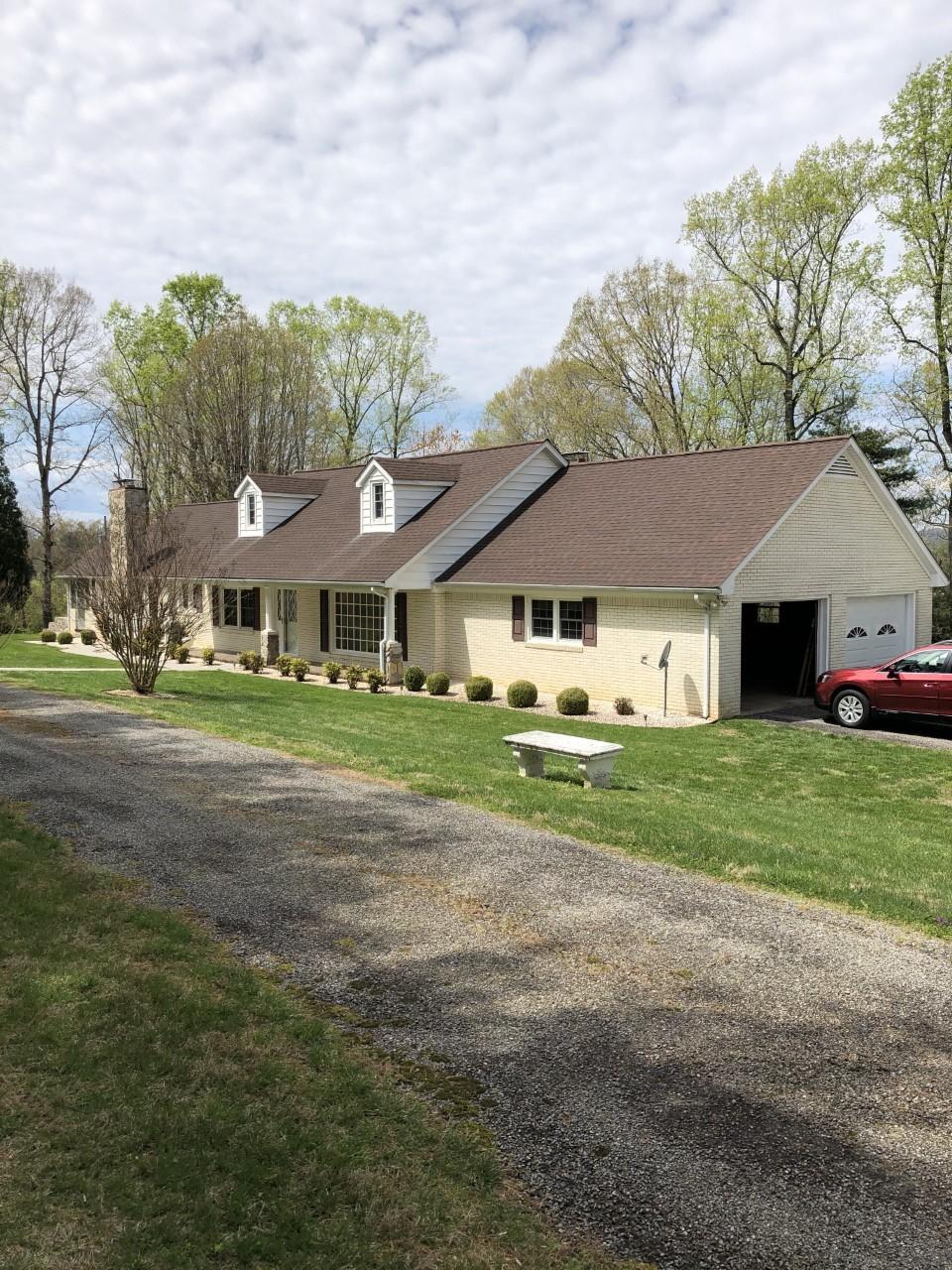 10091 Henry Road Henry, VA 24102 - Photo 2 of 40 a front view of a house with a big yard and potted plants