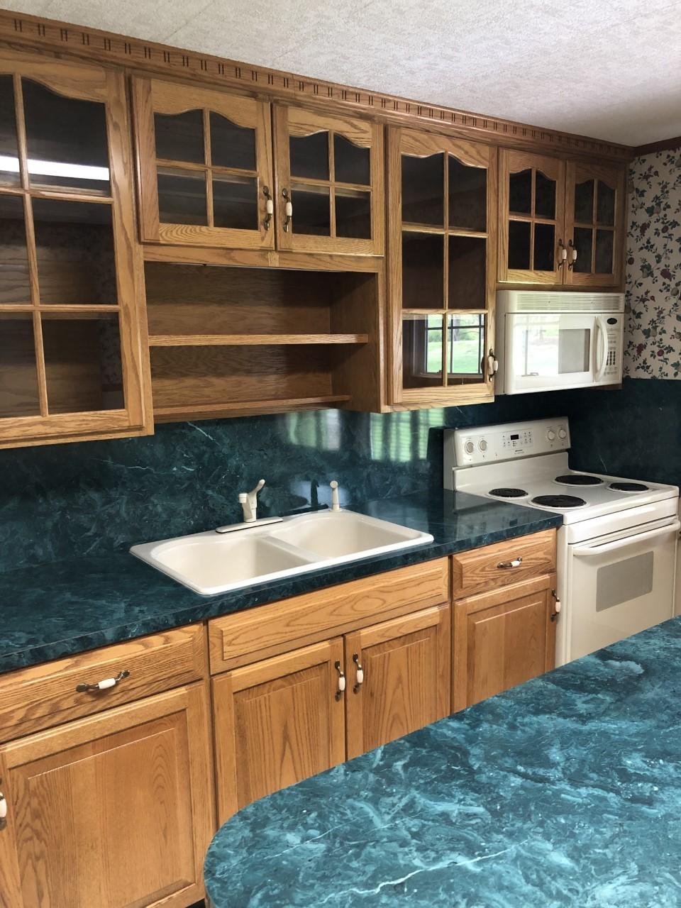 10091 Henry Road Henry, VA 24102 - Photo 16 of 40 a kitchen with granite countertop a sink and cabinets