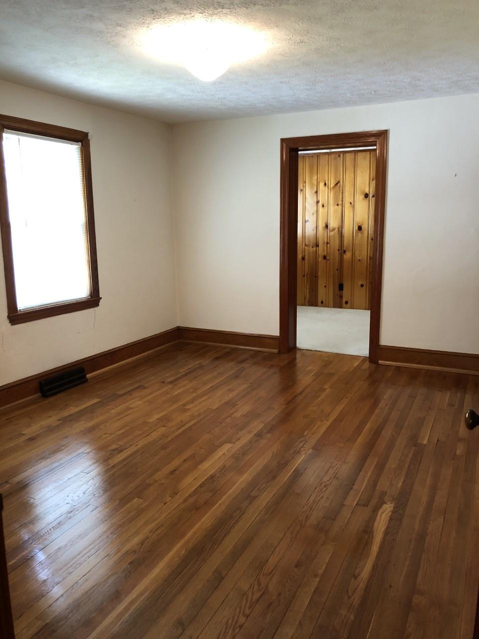 10091 Henry Road Henry, VA 24102 - Photo 22 of 40 an empty room with wooden floor and windows
