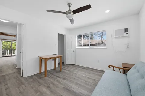 a view of an empty room with window and wooden floor