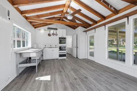 a view of a hallway with wooden floor and a window