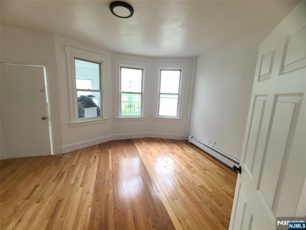 624 Madison Avenue Elizabeth, NJ 07201 - Photo 2 of 10 an empty room with wooden floor and windows