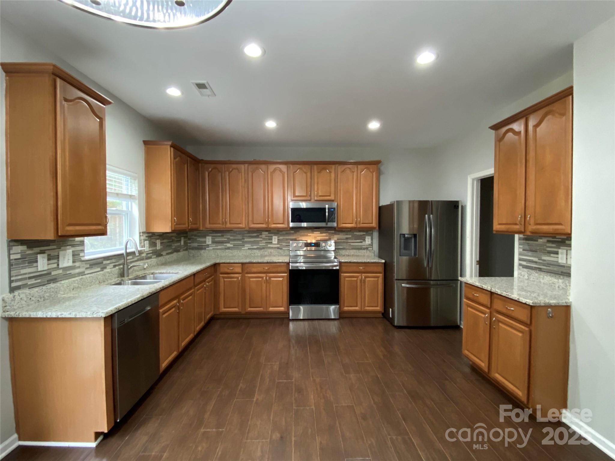7306 Lamplighter Close Drive Matthews, NC 28105 - Photo 3 of 11 a kitchen with a refrigerator a sink and dishwasher with wooden floor