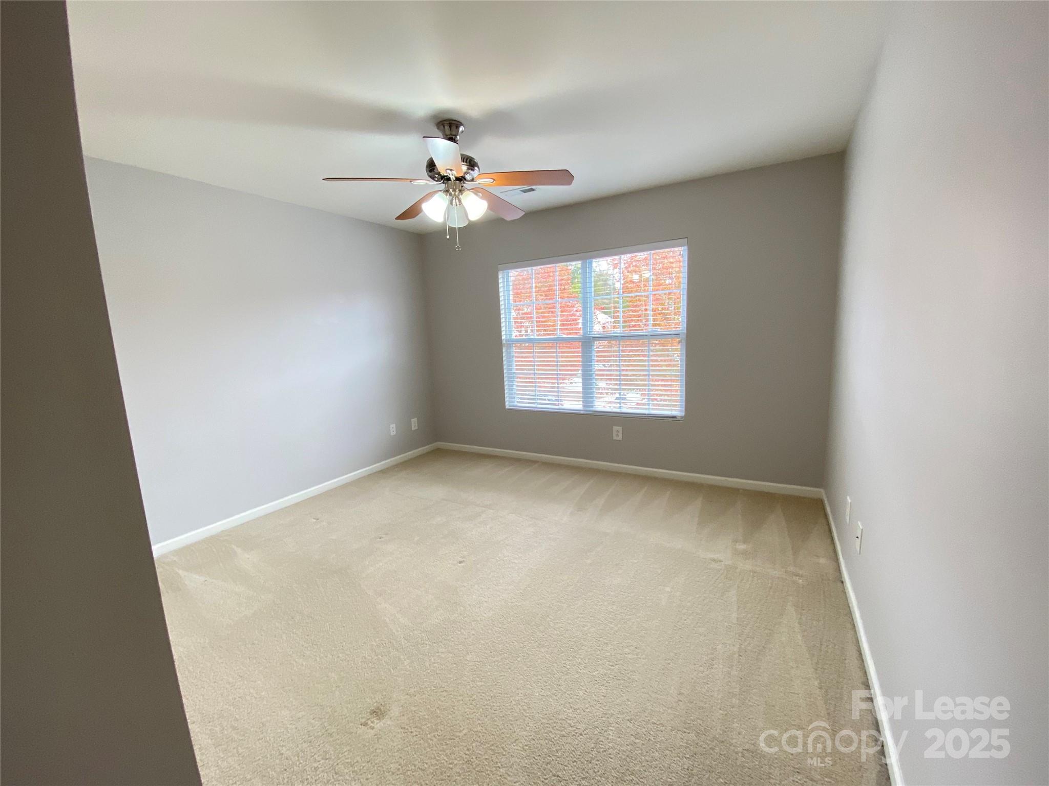 7306 Lamplighter Close Drive Matthews, NC 28105 - Photo 9 of 11 an empty room with a window and a fan
