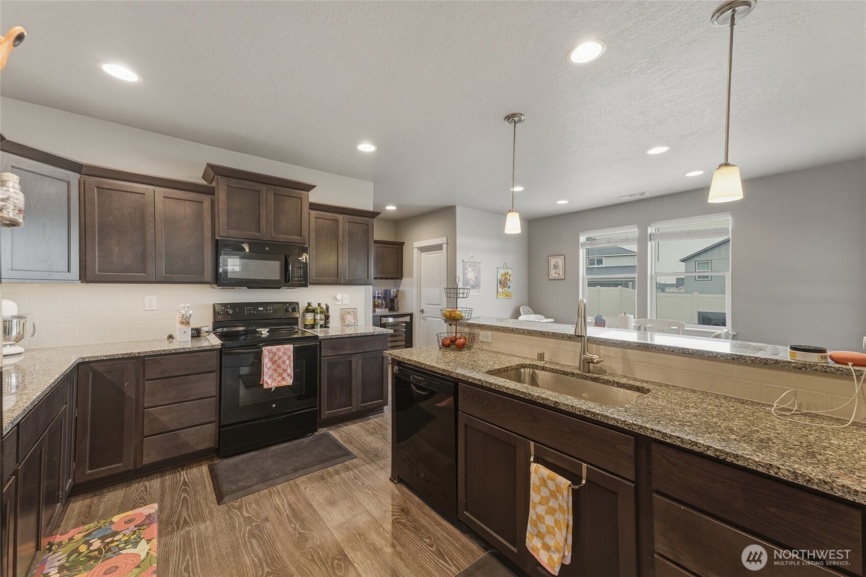 3070 Duval Loop Richland, WA 99352 - Photo 10 of 40 a kitchen with stainless steel appliances granite countertop a sink a stove and a wooden floors