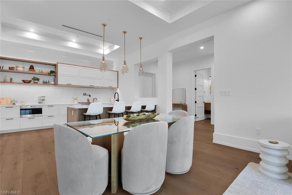 201 8th Street South, Unit 208 Naples, FL 34102 - Photo 11 of 46 a kitchen with a table chairs refrigerator and microwave