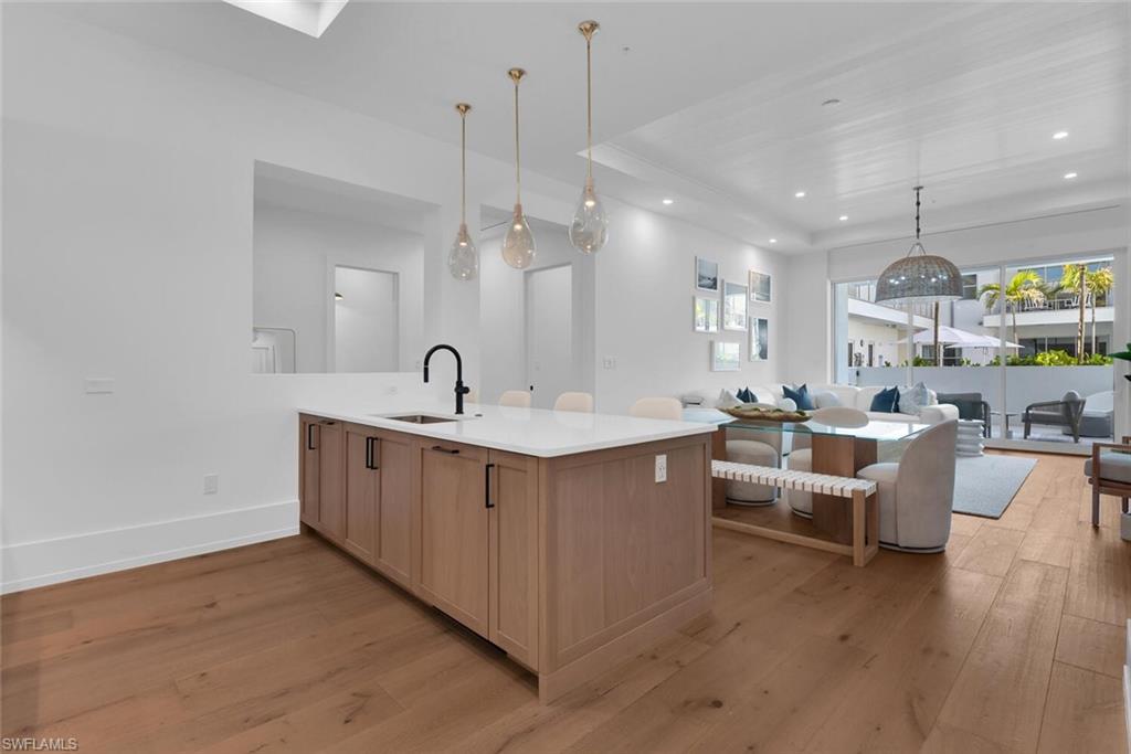 201 8th Street South, Unit 208 Naples, FL 34102 - Photo 45 of 46 a kitchen with counter top space sink stove and wooden floor