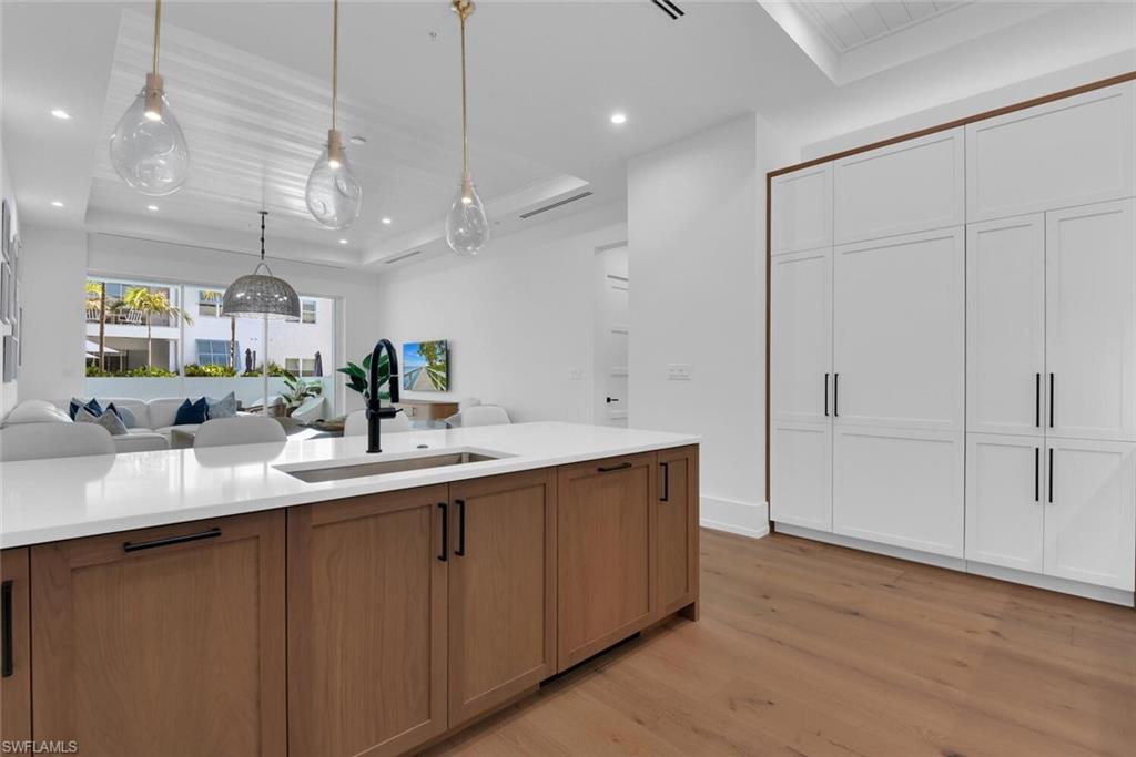 201 8th Street South, Unit 208 Naples, FL 34102 - Photo 46 of 46 a large kitchen with a sink and dishwasher with wooden floor