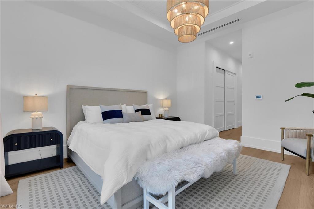 201 8th Street South, Unit 208 Naples, FL 34102 - Photo 14 of 46 a bedroom with a bed and wooden floor