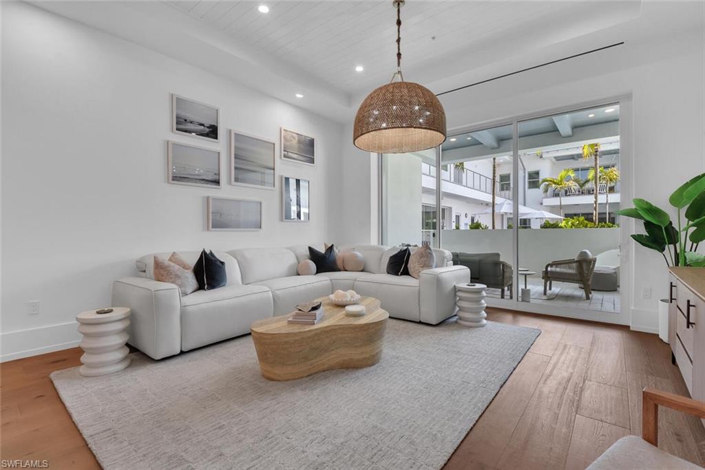 201 8th Street South, Unit 208 Naples, FL 34102 - Photo 5 of 46 a living room with furniture a chandelier and a floor to ceiling window