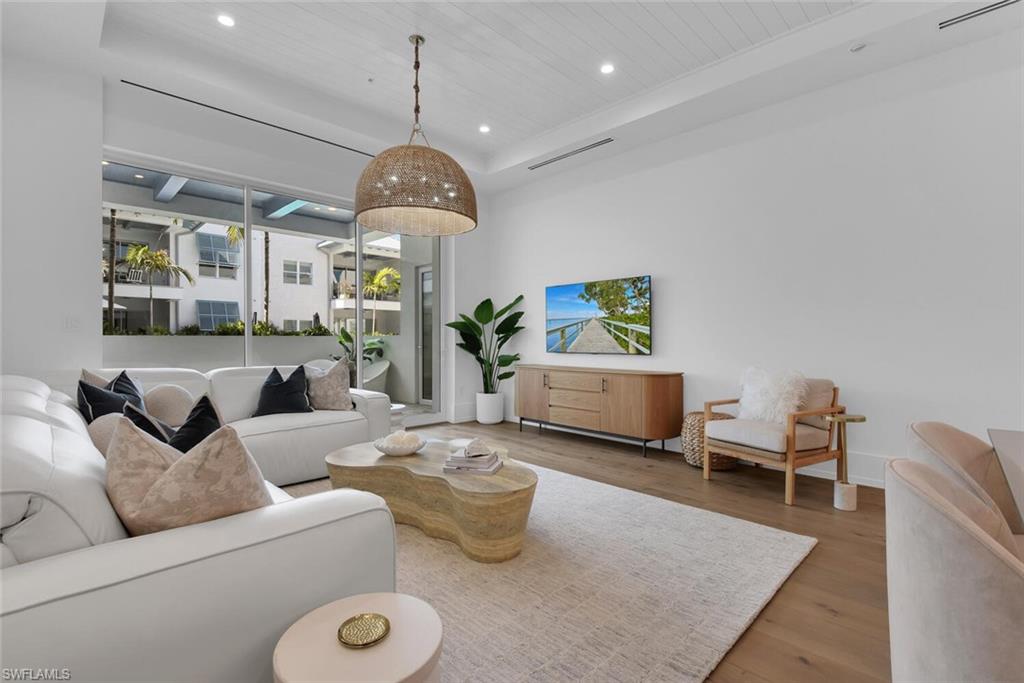 201 8th Street South, Unit 208 Naples, FL 34102 - Photo 6 of 46 a living room with furniture and a chandelier