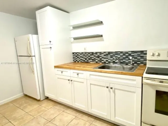 a stove top oven sitting inside of a kitchen