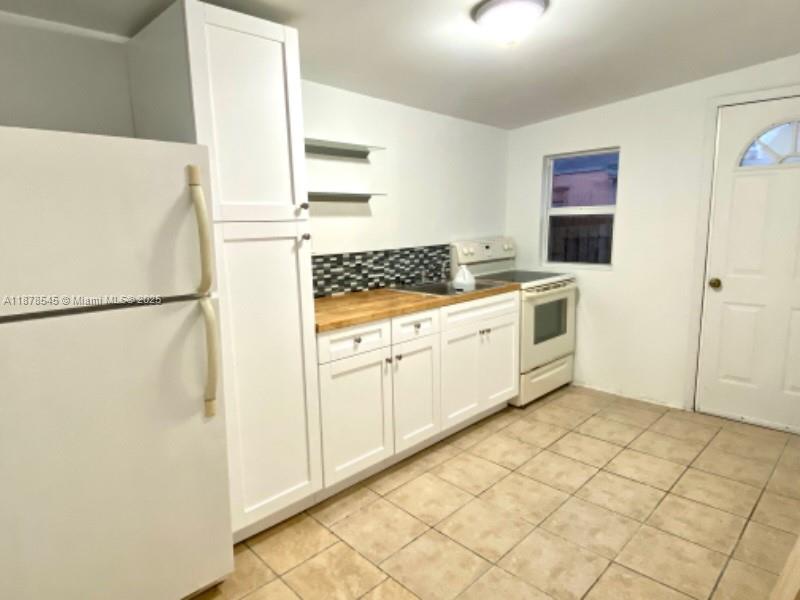 4307 Southwest 9th Street, Unit 4307 Miami, FL 33134 - Photo 2 of 12 a kitchen with white cabinets and white appliances