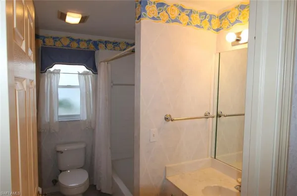 a bathroom with a toilet and a shower