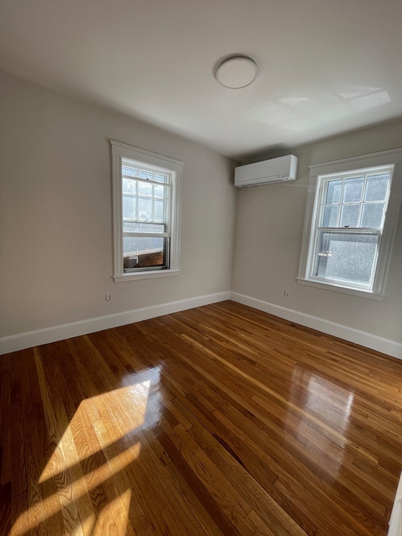 96 Walnut Street, Unit 2 Brookline, MA 02445 - Photo 4 of 13 a view of an empty room with wooden floor and a window