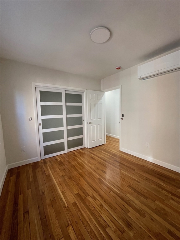 96 Walnut Street, Unit 2 Brookline, MA 02445 - Photo 5 of 13 a view of empty room with wooden floor and fan