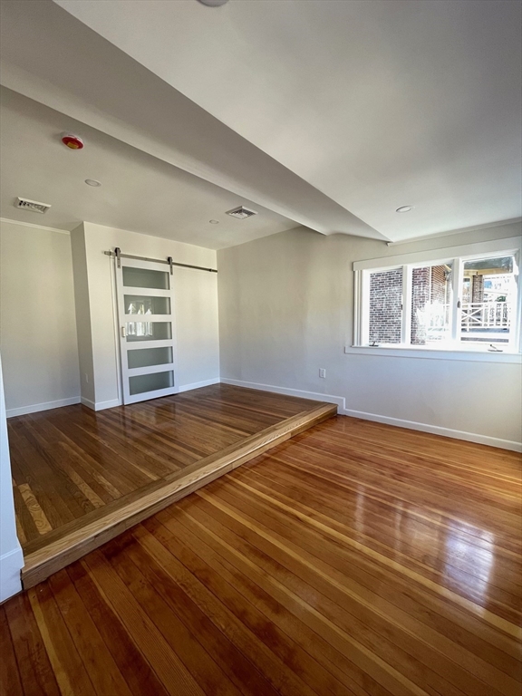 96 Walnut Street, Unit 2 Brookline, MA 02445 - Photo 6 of 13 a view of empty room with wooden floor and fan