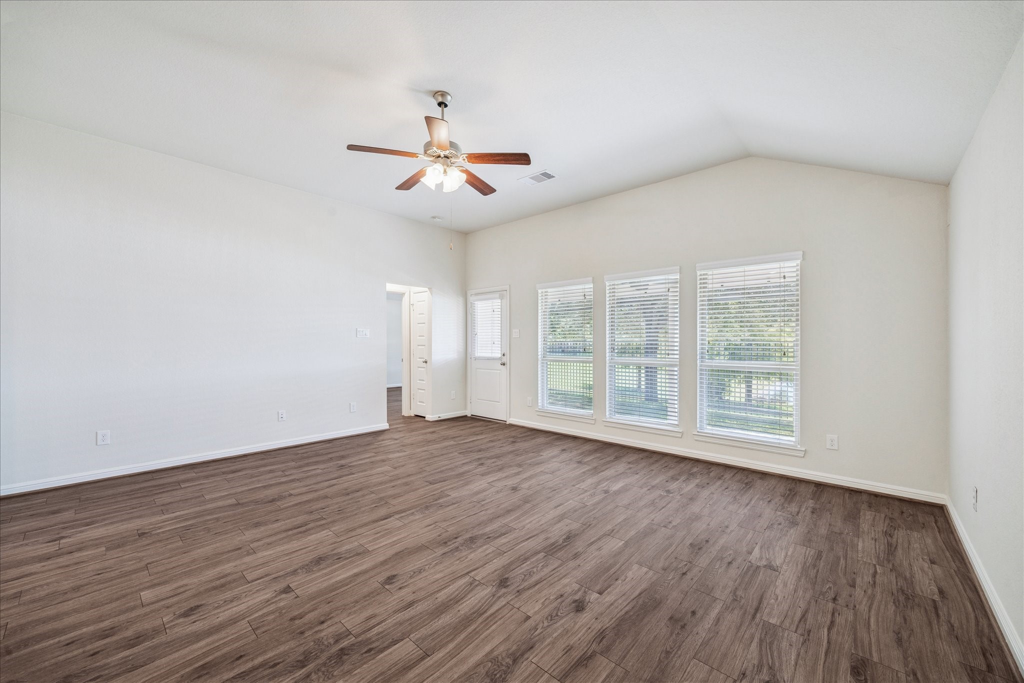 18203 Alora Springs Trace Cypress, TX 77433 - Photo 12 of 30 an empty room with wooden floor fan and windows